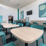 Attraktives Büro-Esszimmer mit modernen Stühlen, bunten Akzenten und ergonomischen Tischen für Workspace.