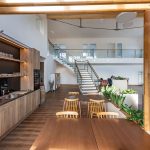 Helles, offenes Living Office mit nachhaltigem Holzdesign und Pflanzen für inspirierende Arbeitsatmosphäre.