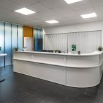 Heller Empfangstresen mit Pflanzen, Corporate Design, minimalistisches Innenraumdesign.