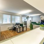 Alt Text: Helles Büro mit modernen Möbeln, Pflanzen und Arbeitsplatzgestaltung im Living Office Stil.