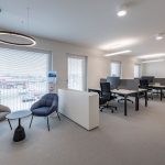 Helles Büro mit Living Office Design, flexible Arbeitsplätze, moderne Einrichtung und ergonomische Arbeitsplätze.