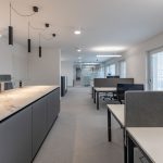 Helles Office-Design mit modernen Möbeln und Arbeitsstationen in einem lichtdurchfluteten Büro.