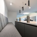 Helle, minimalistische Office Design mit Sitzbank und innovativer Beleuchtung.