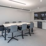 Heller Konferenzraum mit eleganten Stühlen und moderner Technik für effiziente Meetings.