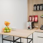 Moderne Küchenzeile mit Obst und Kaffeemaschine.